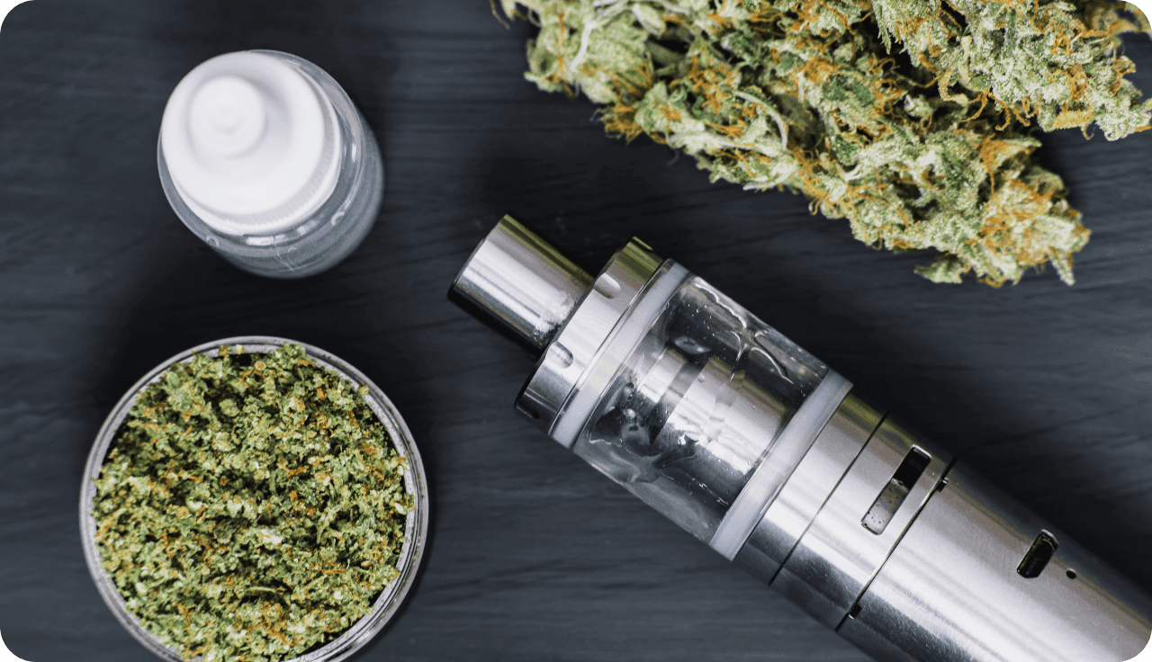 Ein modernes Vape-Gerät mit Cannabisblüten und E-Liquid-Flasche.